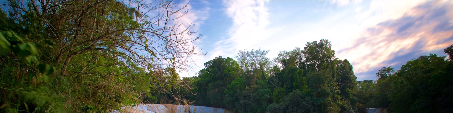 A natural landscape with a series of cascading waterfalls and a turquoise river flowing through rocky terrain.