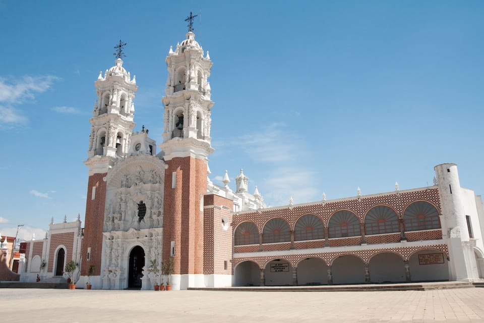 Una iglesia histórica con dos torres de campanas y una amplia entrada en arco.