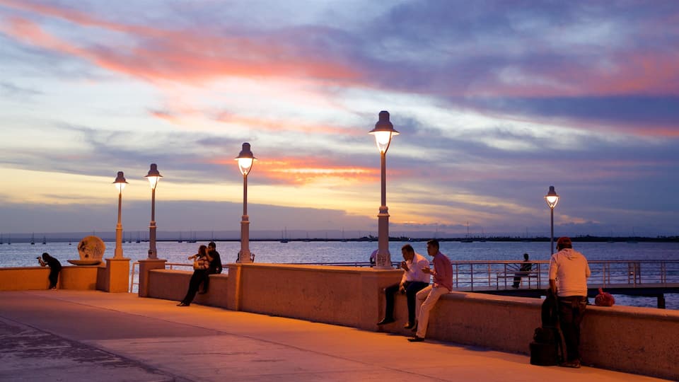 Malecon Kiosk showing a sunset and general coastal views as well as a small group of people