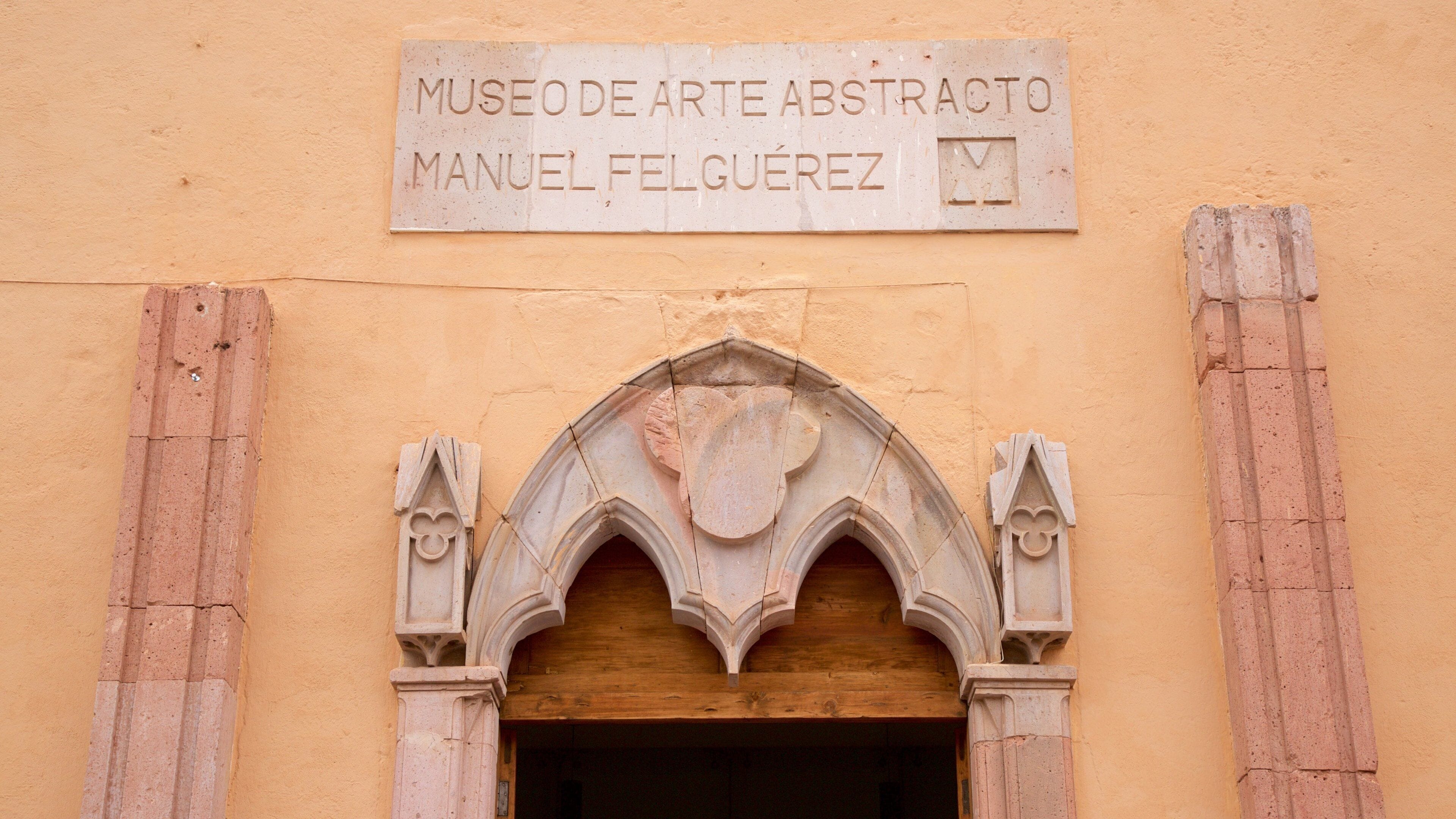Entrada de edificio con un cartel que dice "Museo de Arte Abstracto Manuel Felguérez".