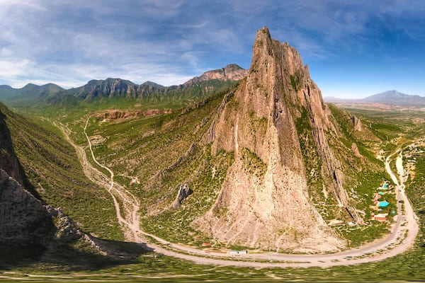 Un paysage montagneux caractĂ©risĂ© par dâimposantes formations rocheuses et une route sinueuse.