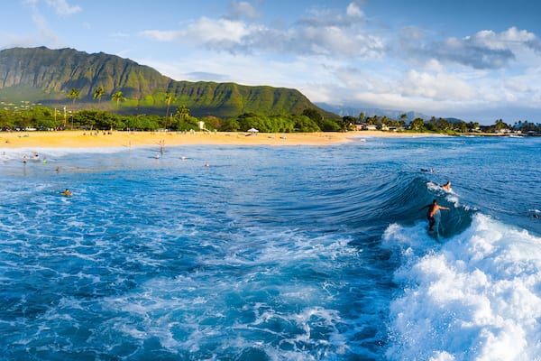 Panorama of the surf spot Makaha with the surfer riding the wave. Oahu, Hawaii