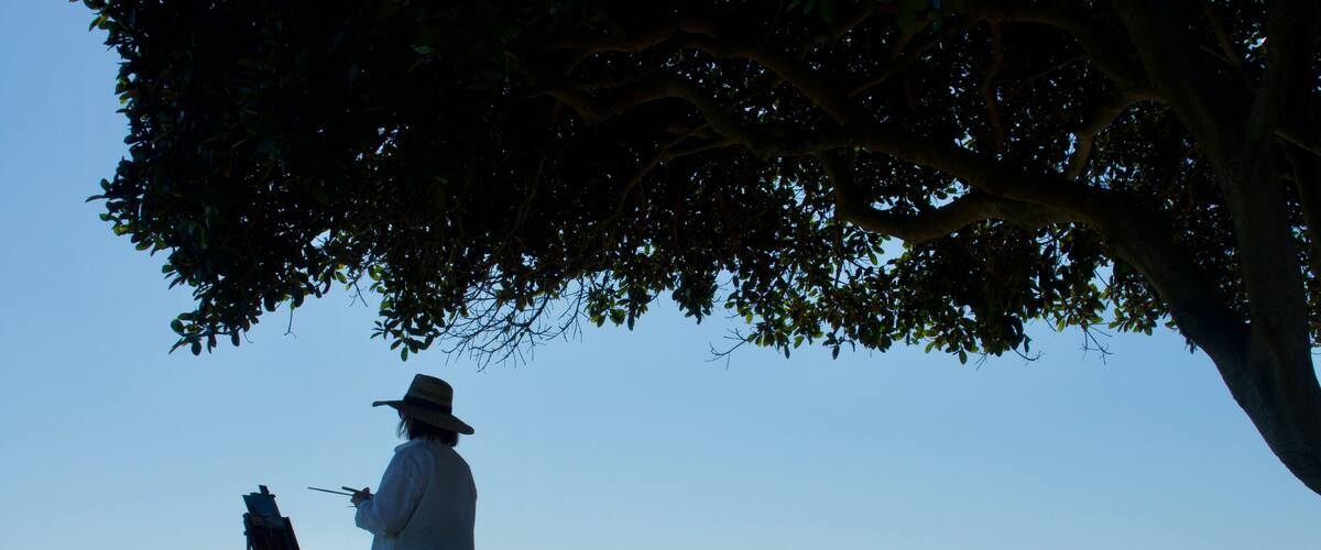 silhouette of landscape painter at sunset