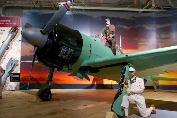 A historical aircraft on display with a backdrop of a sunset sky.