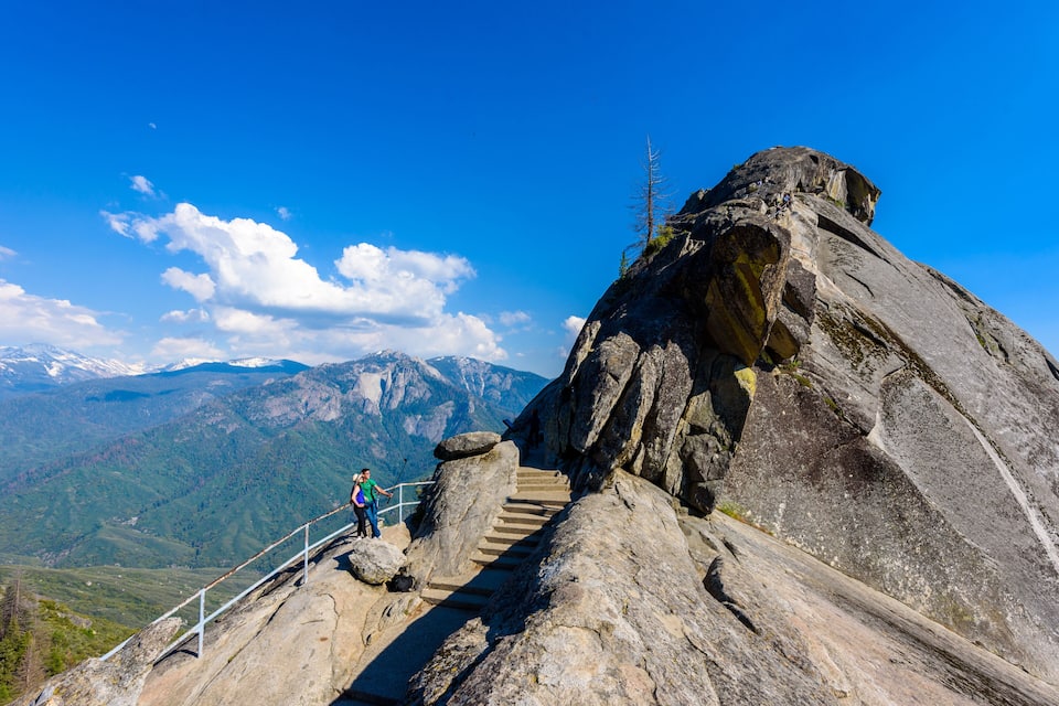 Une montagne rocheuse avec un escalier qui monte vers le sommet.