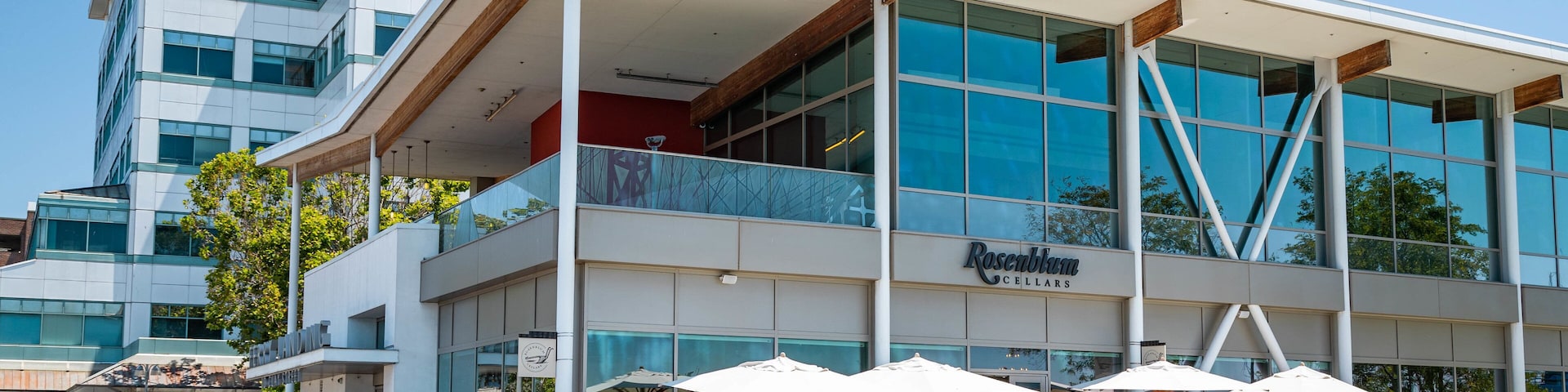 A modern building with a glass facade and a sign reading "Rosebloom Cellars".