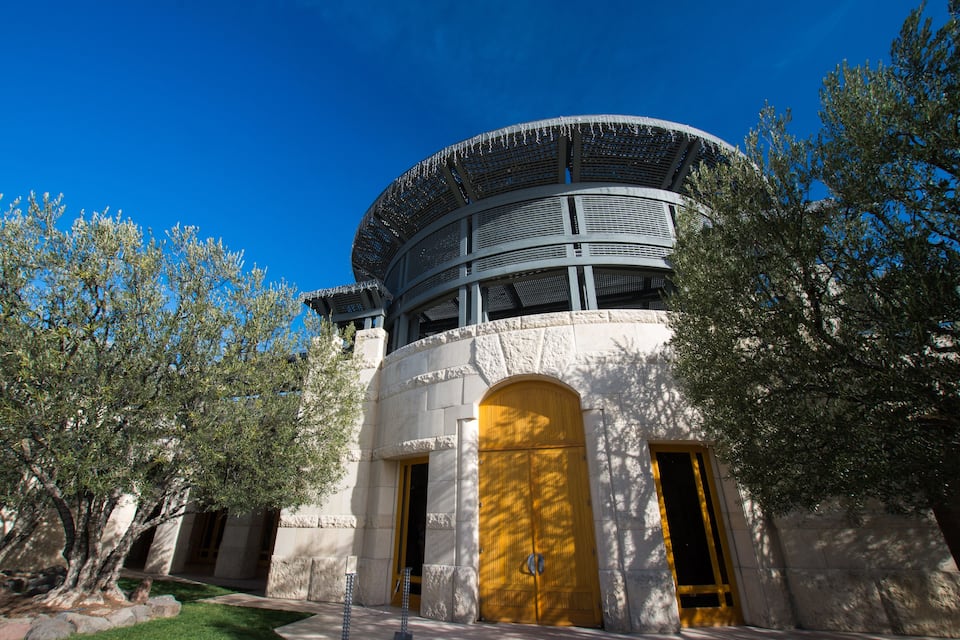 A building with a circular top, arched doors, and a stone facade.