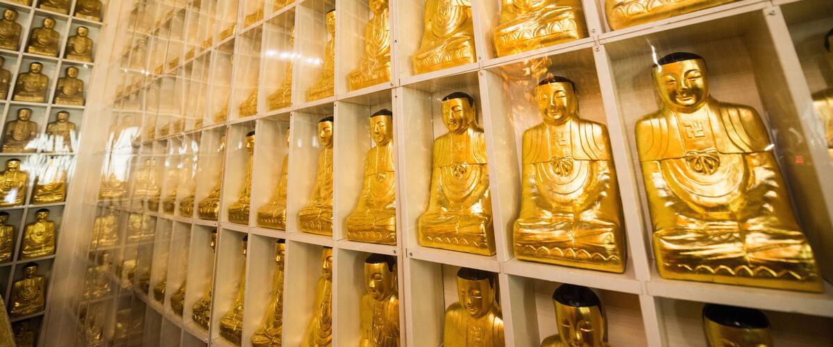 A detail of one of the walls of the Jeweled Hall of 10,000 Buddhas that is lined with golden statues in the City Of Ten Thousand Buddhas in Ukiah, California.