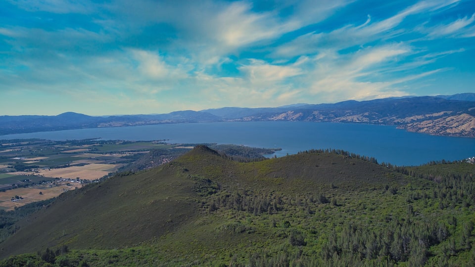 A mountainous landscape with a lake and distant mountains.