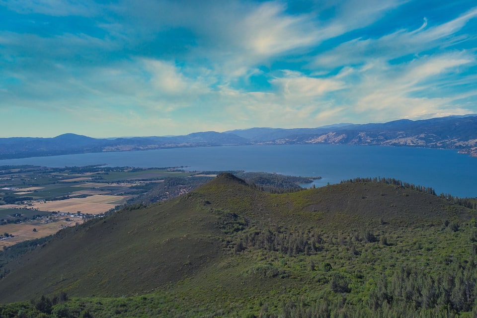 A mountainous landscape with a lake and distant mountains.