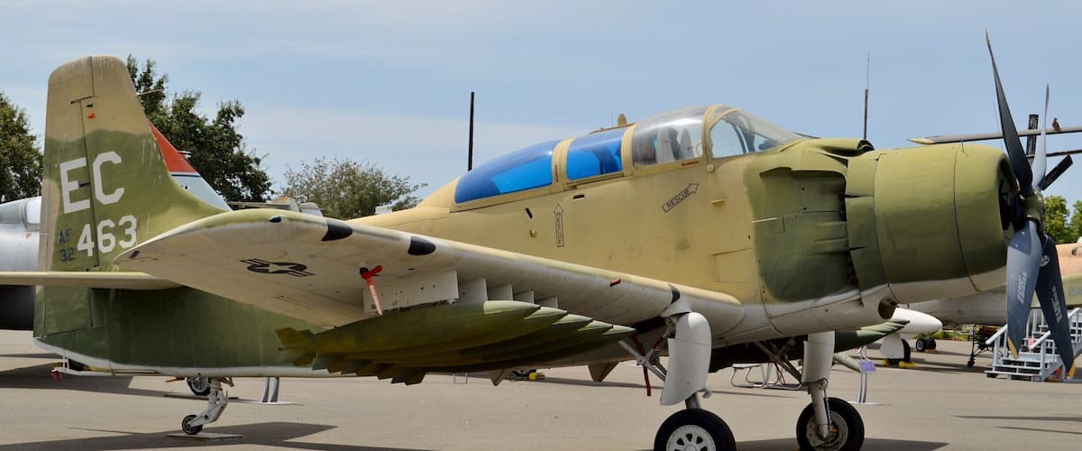 A vintage military aircraft with camouflage paint, a propeller, and a tail marked with "EC 463".