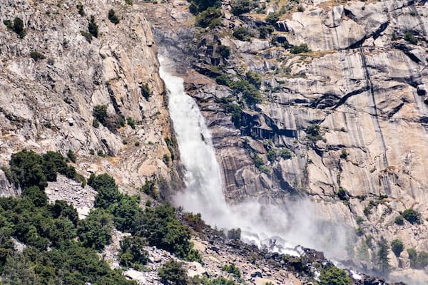 View towards Wapama falls dropping along granite walls; Hetch Hetchy Reservoir area, Yosemite National Park, Sierra Nevada mountains, California