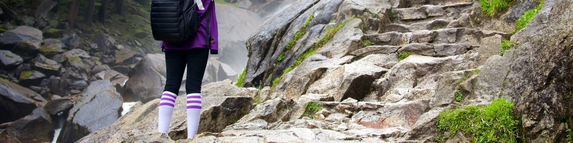 A waterfall with hikers on a rocky path.