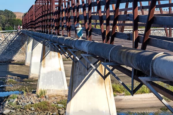 Distinctive wooden trestle footbridge used by bicyclists, runners and dog walkers to cross over the Santa Ana River. Huntington Beach, CA.
