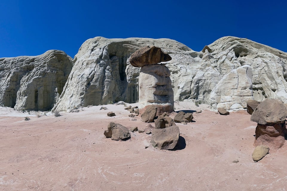 A desert landscape with large rock formations and a clear blue sky.