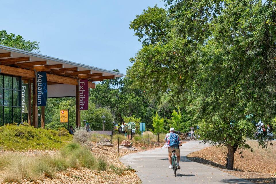A modern building with banners for the Museum Store, Aquarium, and Exhibits.