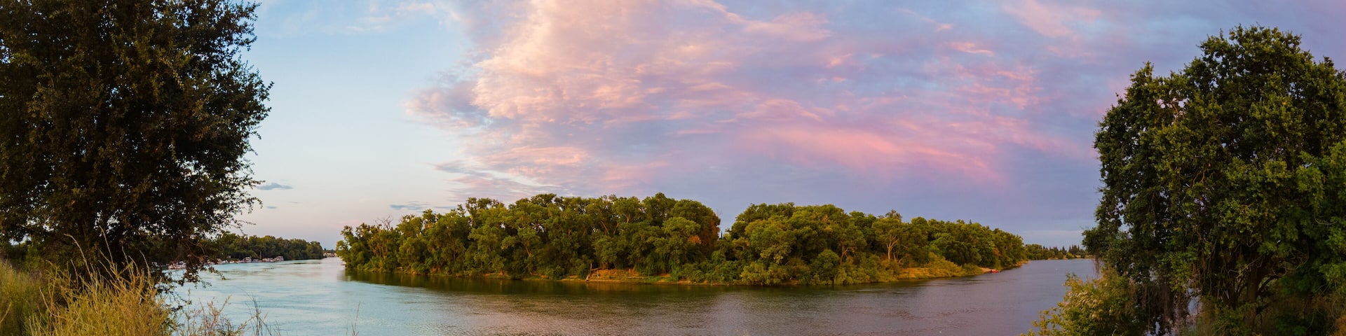 Panoramic landscape view of Sacramento river near pocket area at sunset