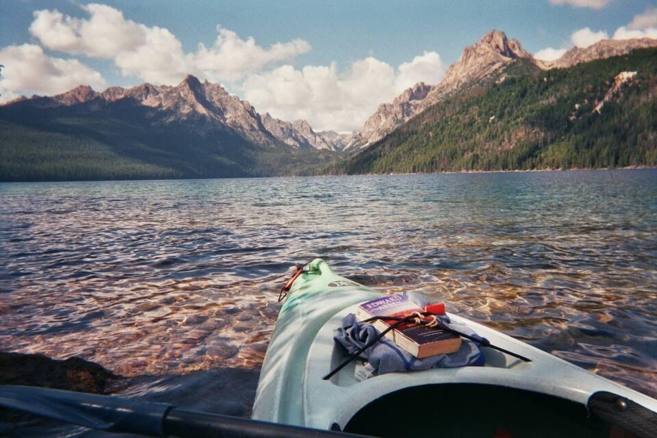 A kayak on a calm lake with mountains in the background.