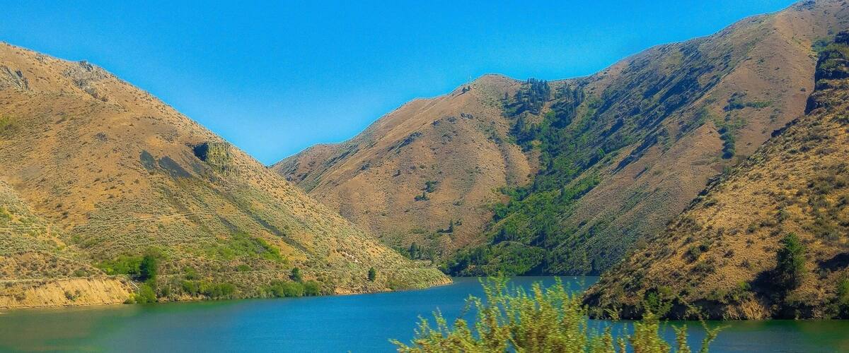 A mountainous landscape with a clear blue lake surrounded by rugged terrain.
