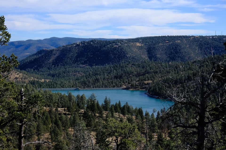 Un lago rodeado de bosques y colinas densas.