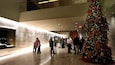 A modern indoor space with a large Christmas tree decorated with ornaments and lights.