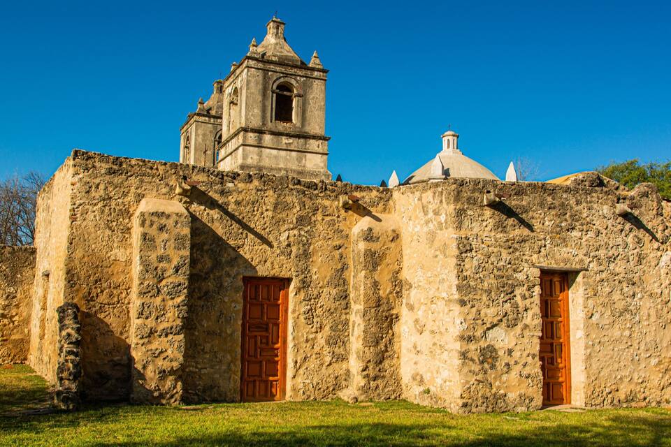Un edificio histórico de piedra con un campanario y dos puertas de madera.