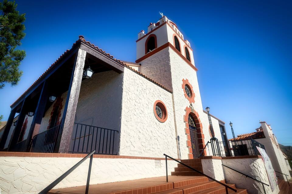 Una església històrica amb un campanar, finestres d'arc i teulada d'atles.