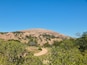 A hill with a dirt path leading to its summit.