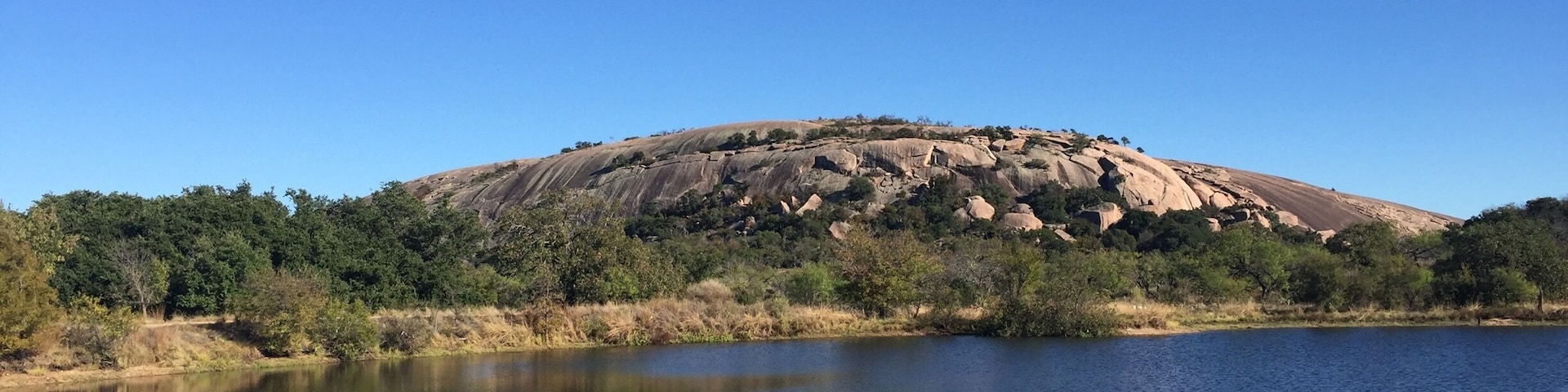View of the west side of Enchanted Rock across Moss Lake. This state natural area offers spectacular hiking opportunities.