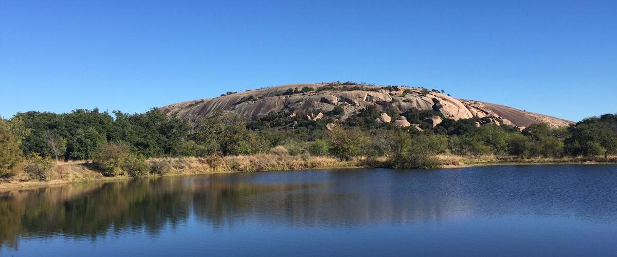 View of the west side of Enchanted Rock across Moss Lake. This state natural area offers spectacular hiking opportunities.