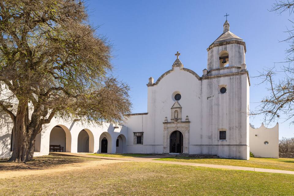 A white church with a bell tower and arched windows.
