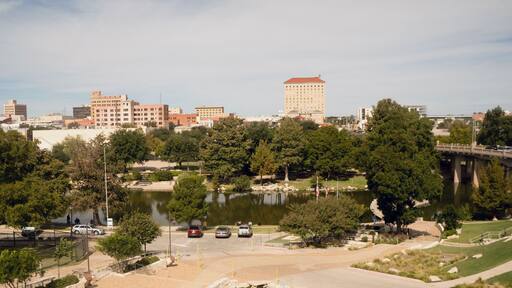 A cityscape with a large building, a bridge, and a lake.