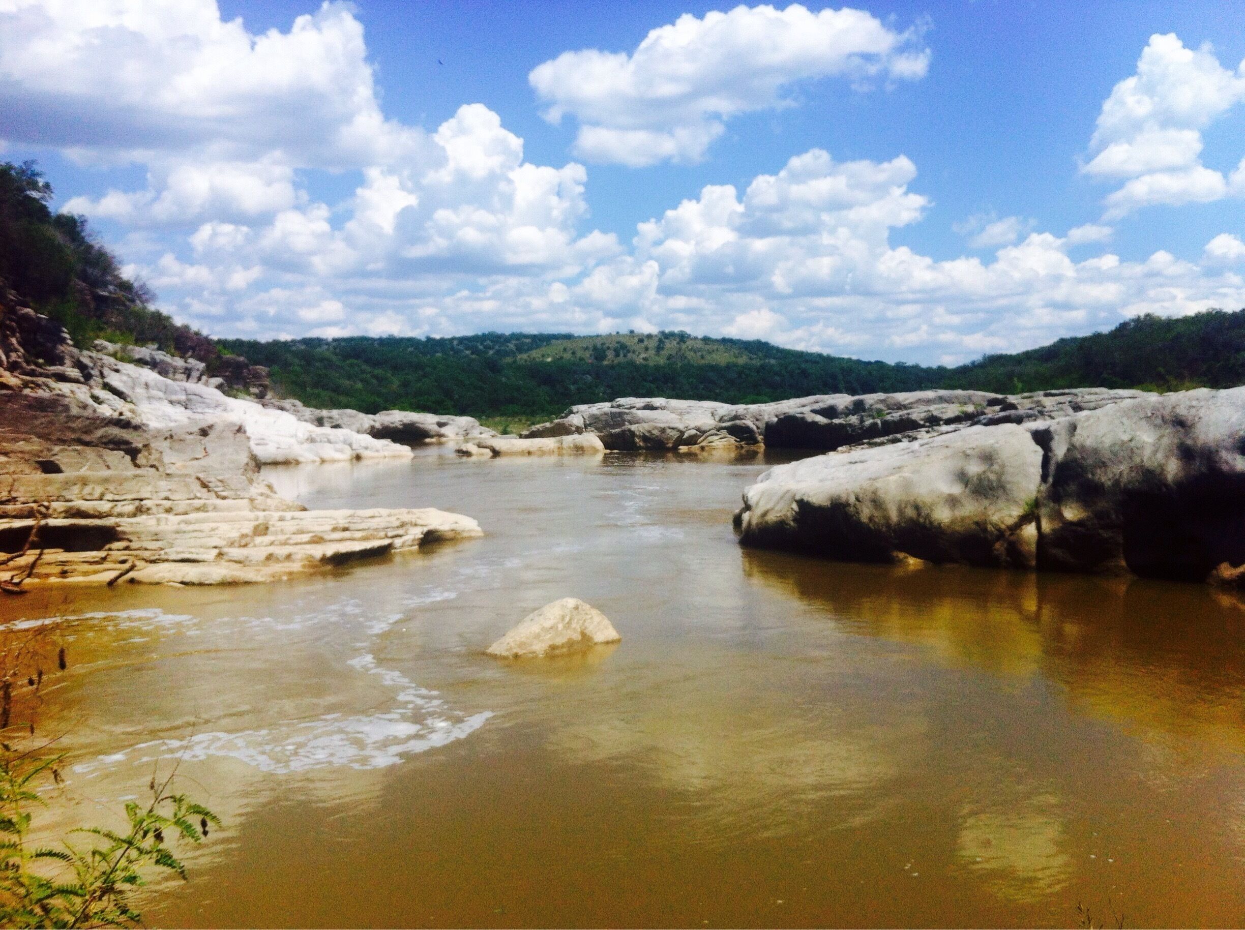 A river with rocky banks and a clear sky.