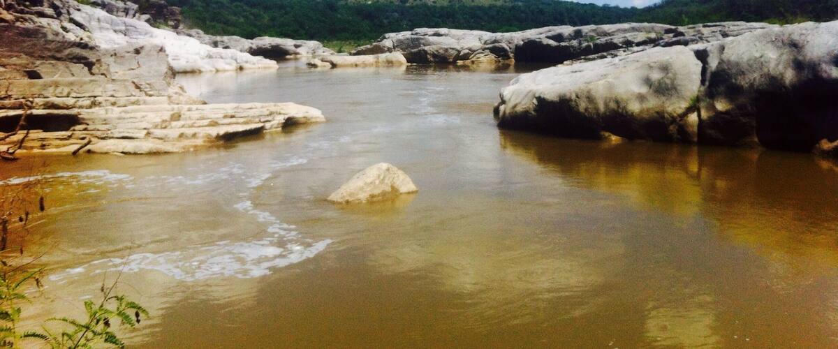 A river with rocky banks and a clear sky.