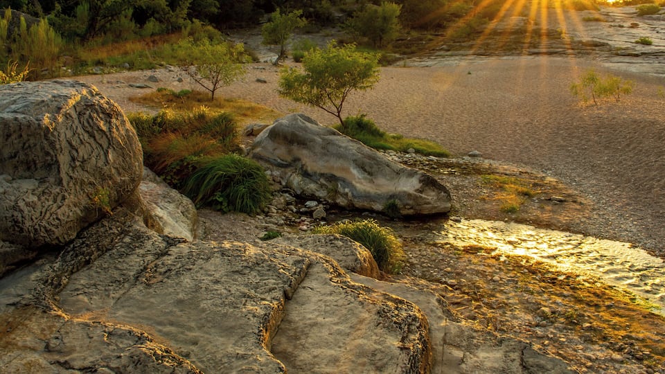 A rocky landscape with large boulders and sparse vegetation.