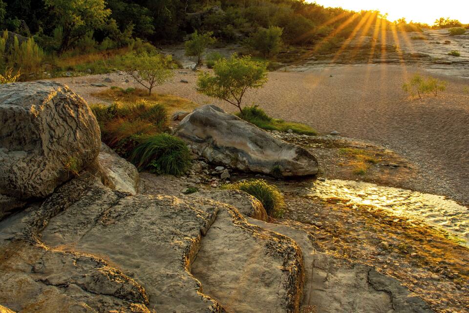 A rocky landscape with large boulders and sparse vegetation.