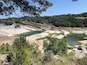 Un paysage naturel comprenant une rivière, un terrain rocheux et une végétation luxuriante.