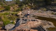Man hiking on rocks across creek at Inks Lake State Park in Texas