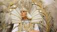 Una persona amb un vestit daurat i blanc amb una cresta emplumada.