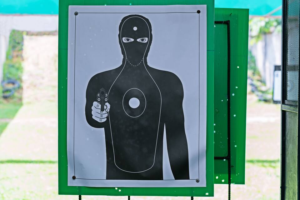 A target board with a silhouette of a person holding a gun.