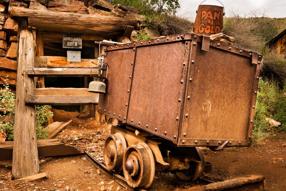 Een oude, roestige treinwagon met een bordje met de tekst 'PAN & GOLD'.