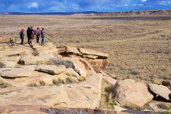 Petrified Forest National Park das einen ruhige Szenerie und Wüstenblick sowie kleine Menschengruppe