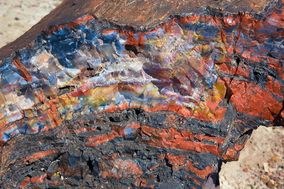 Een detailopname van een rots met levendige, veelkleurige mineralen.