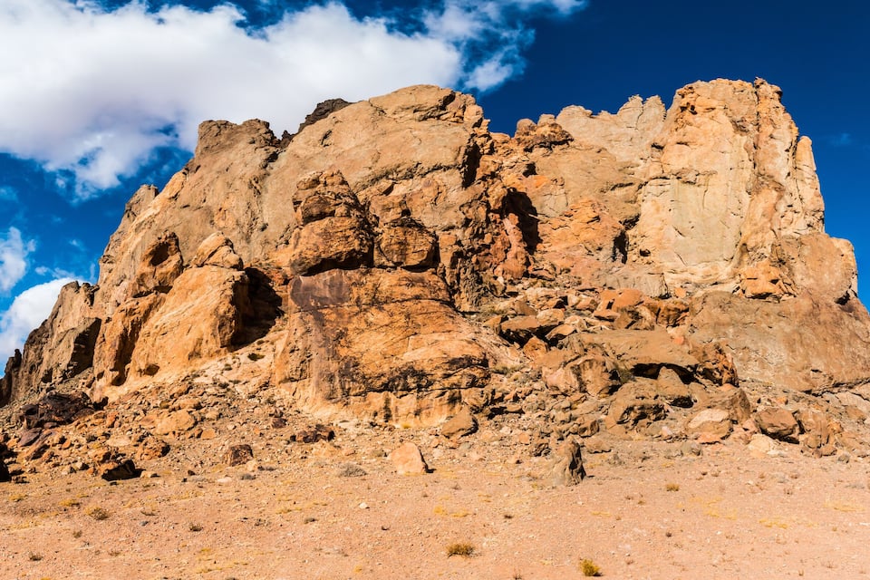 A rugged, rocky mountain peak under a clear blue sky.