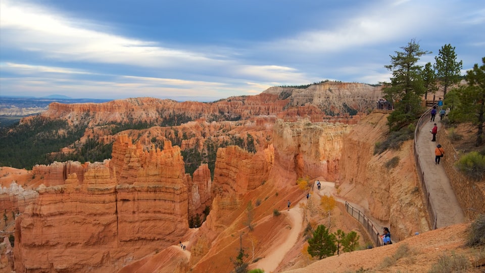 A canyon with red rock formations, a trail, and people hiking.