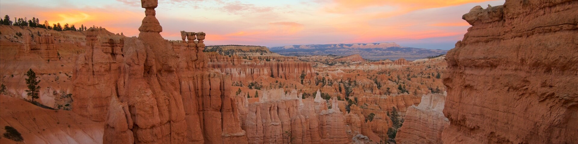 Um cânion com formações rochosas únicas e um céu ao pôr do sol.