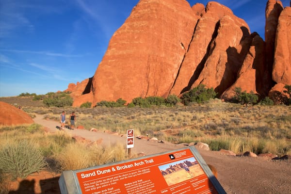 Sand Dune Arch which includes signage, a gorge or canyon and desert views