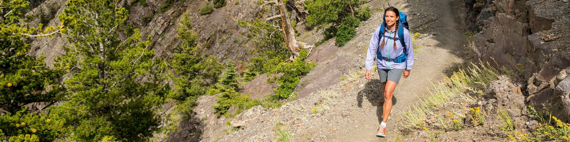 A woman hiking along the Bear Creek National Recreation Trail, Uncompahgre National Forest, Ouray, Colorado.