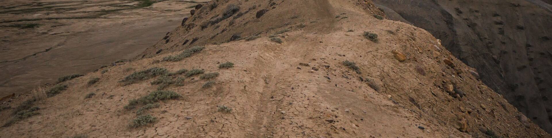 Narrow Trail on top of adobe clay ridgeline on hill in Peach Valley badlands in off road recreation area near Montrose Colorado