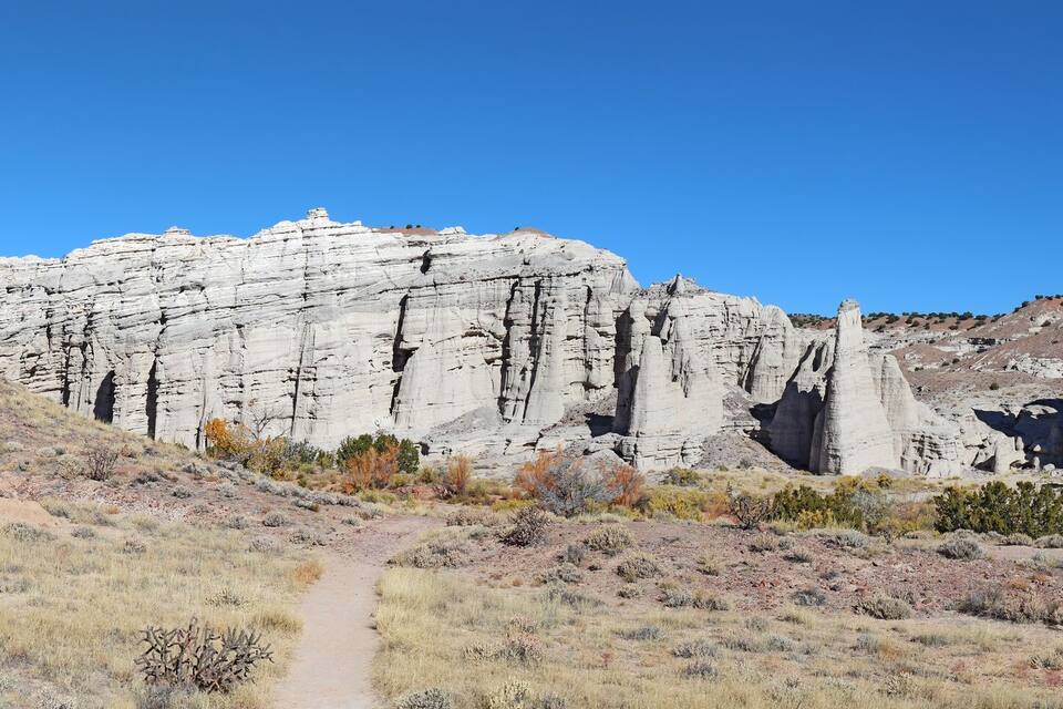 Paisaje desértico con formaciones rocosas blancas destacadas y un cielo azul despejado.